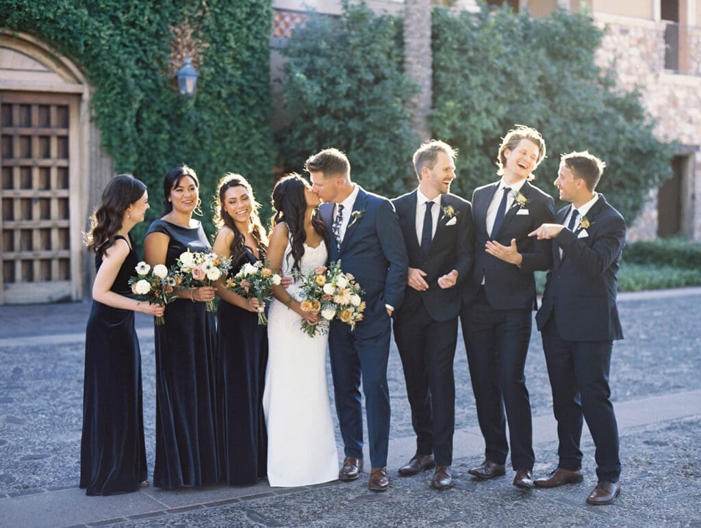Bride and groom posing for photos with their wedding party at Blackstone Country Club in Peoria, Arizona