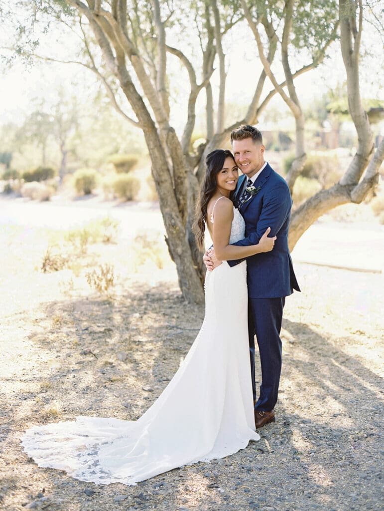 Bride and groom holding each other close during their portraits at Blackstone Country Club - Arizona desert wedding venue. 