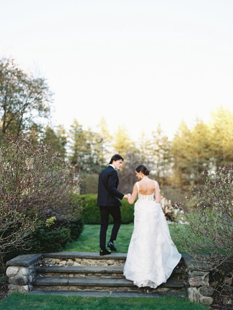Bride and groom walking up steps at Green Crest Manor wedding venue in Battle Creek, Michigan