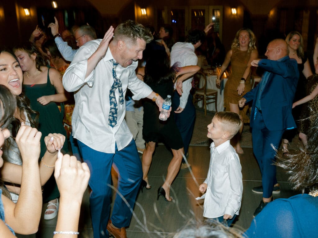 Groom dancing with his son during their wedding reception