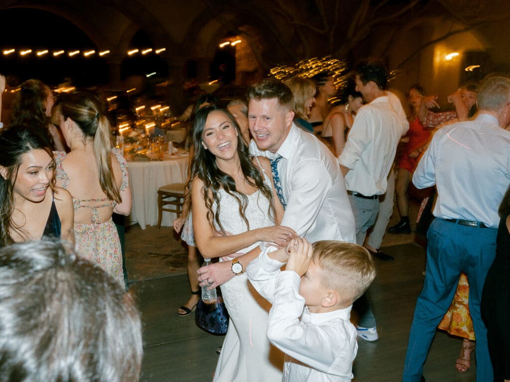 Bride, groom and their son dancing during the wedding reception