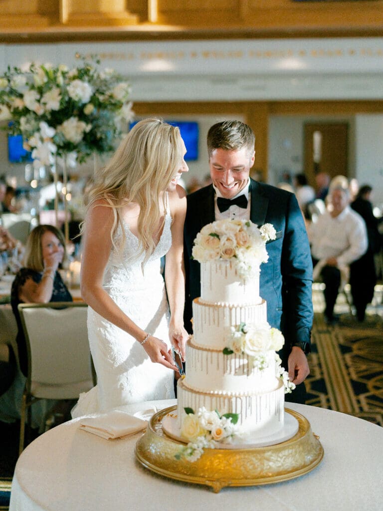 Bride and groom cutting into their wedding cake during their Notre Dame wedding reception in Dahnke Ballroom