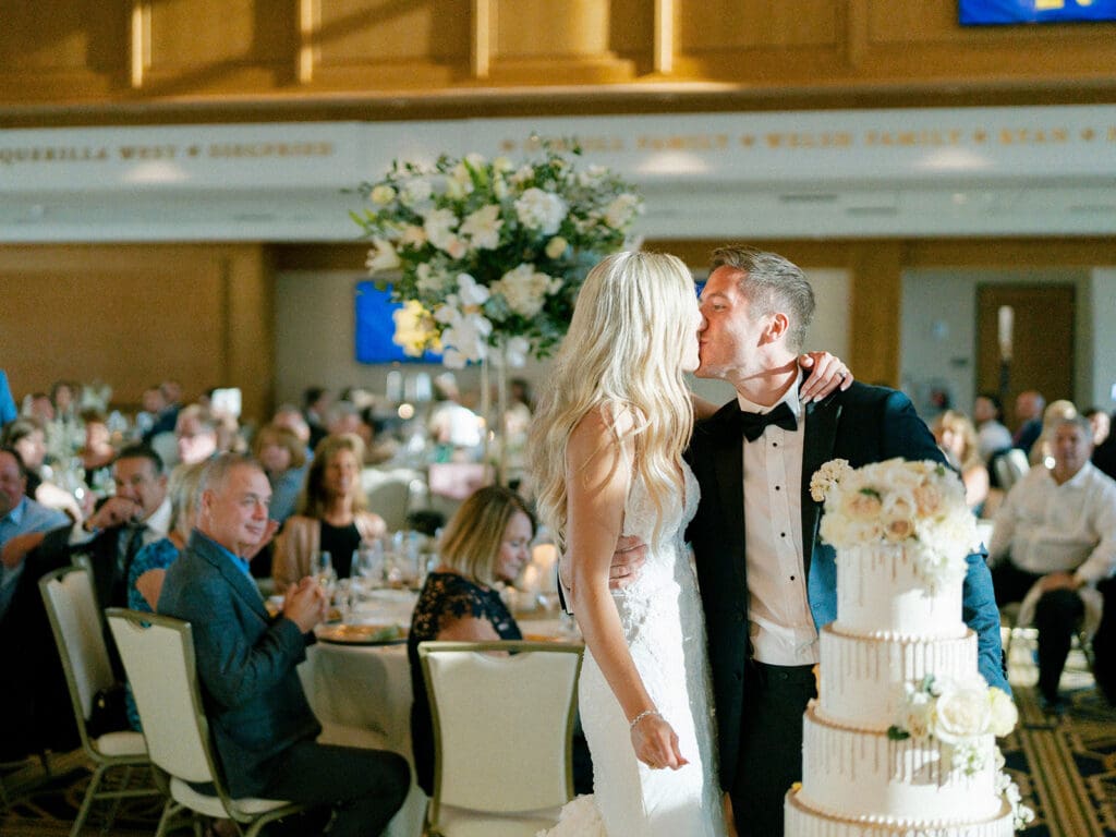 Bride and groom kissing after cake cutting