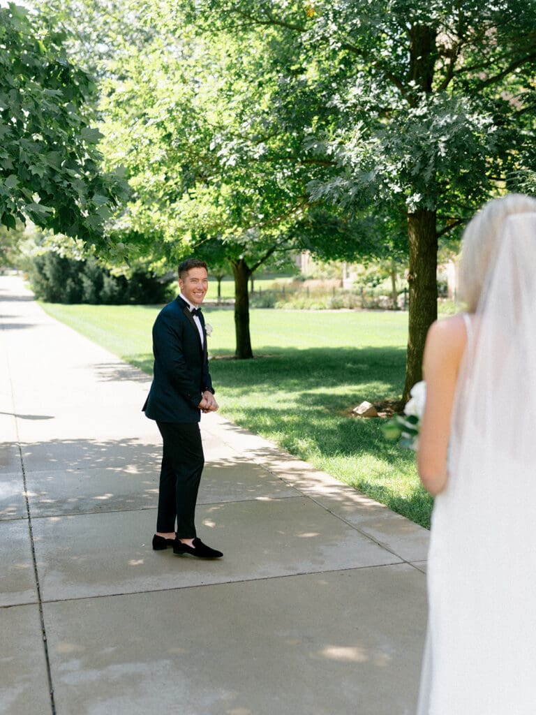 Groom turning around to see his bride during their first looks