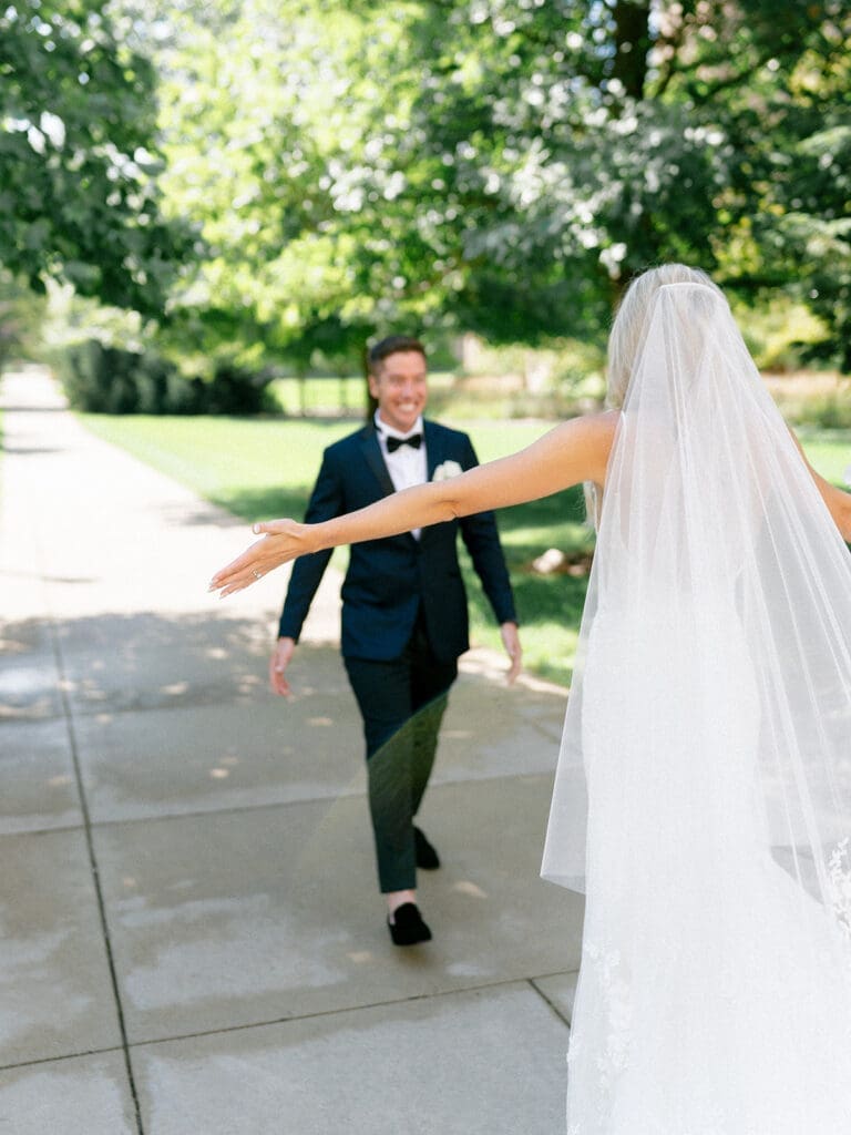 Groom smiling and in awe as he turns around to see his bride to be during their first looks