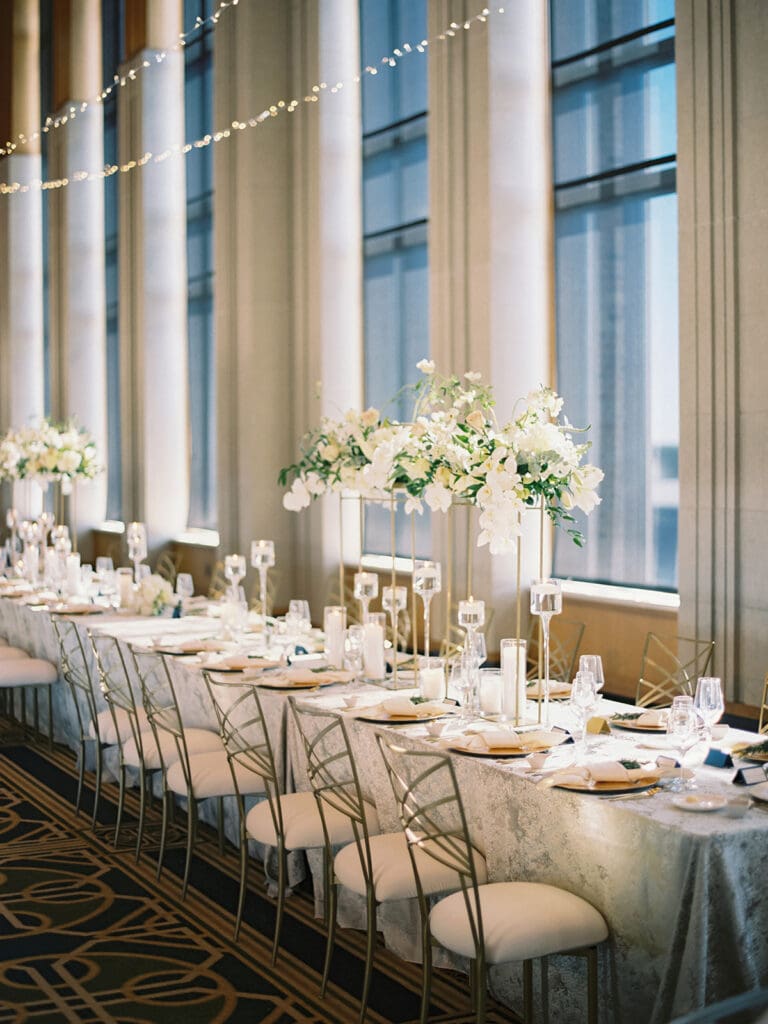 An indoor Notre Dame wedding reception in Dahnke Ballroom with gold and white accents and white florals