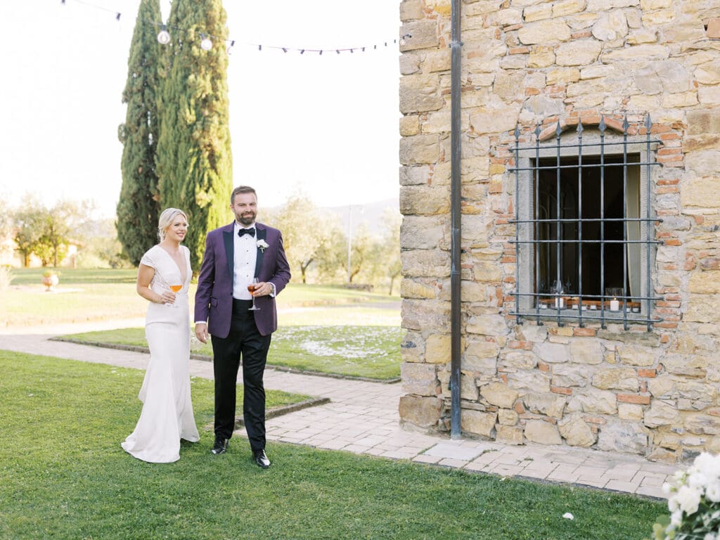 Bride and groom entering their outdoor summer wedding reception at Villa Petrea in Italy