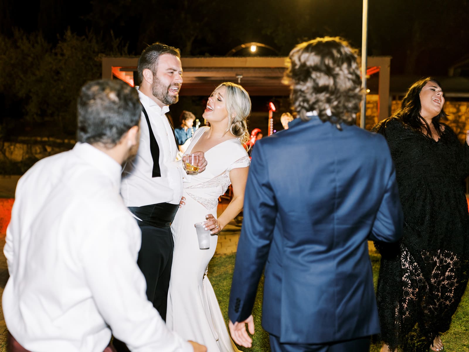 Bride and groom dancing and singing with their wedding guests during their reception