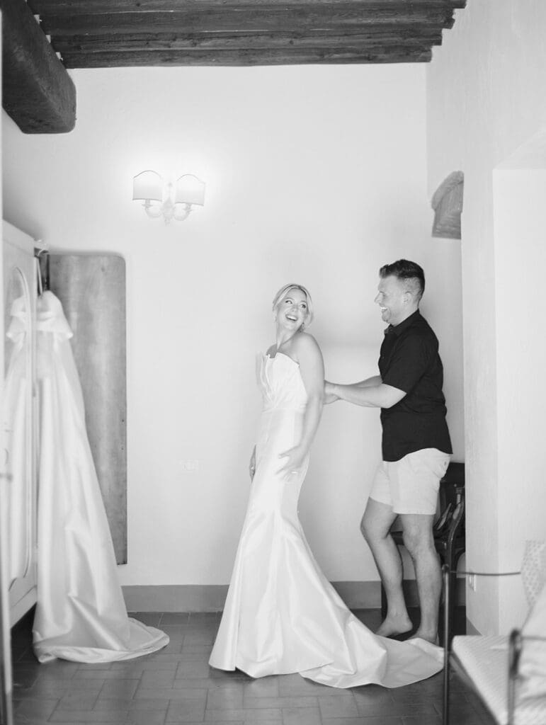 Black and white photo of a bride getting ready with one of her close friends.