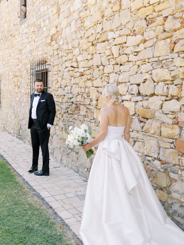 Groom turning around and seeing his bride during their first looks from their summer wedding in Tuscany, Italy at Villa Petrea