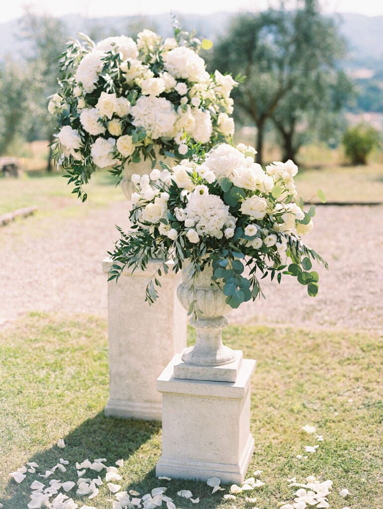 Lush white wedding flower arrangements for a summer wedding ceremony in Tuscany, Italy.
