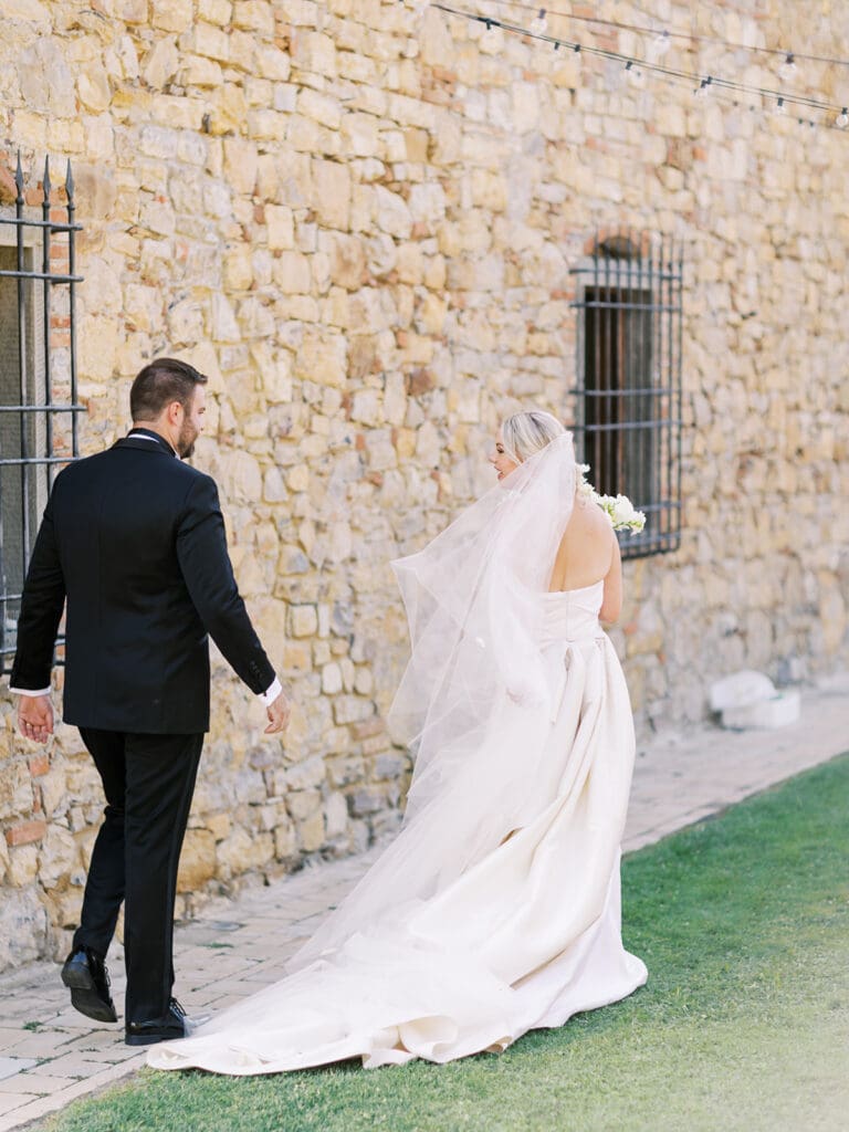 Bride and groom walking away after their outdoor summer wedding ceremony at Villa Petrea. 