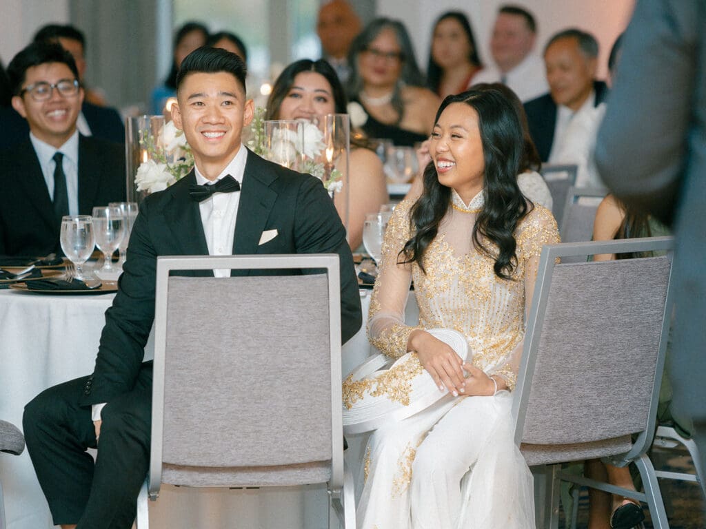 Bride and groom laughing during their wedding speeches
