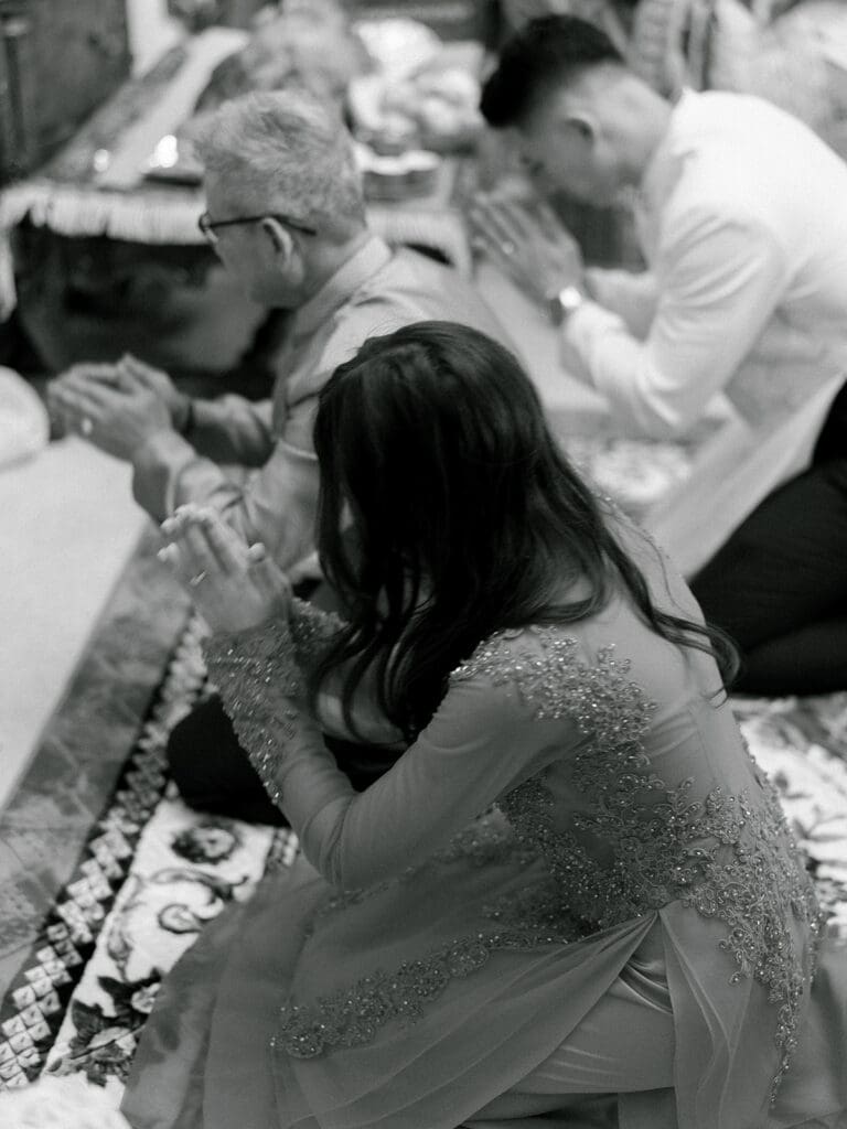 Bride and groom doing an alter prayer during their at-home Lao and Vietnamese wedding ceremony in Indiana
