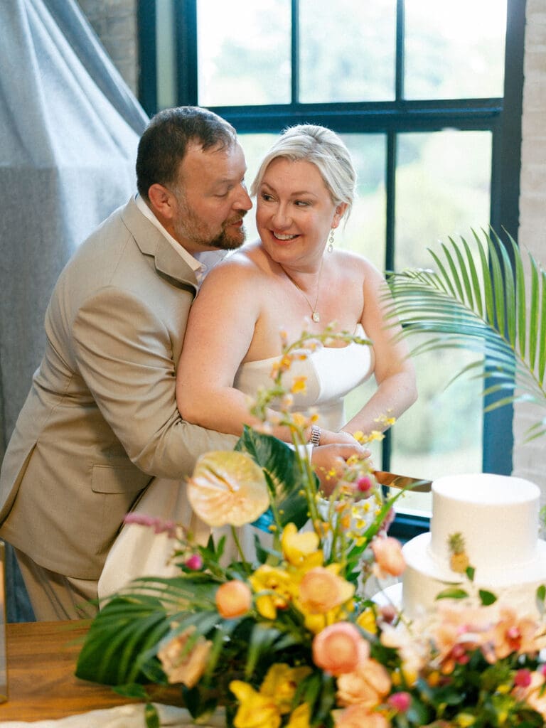 Bride and groom cutting into their wedding cake 