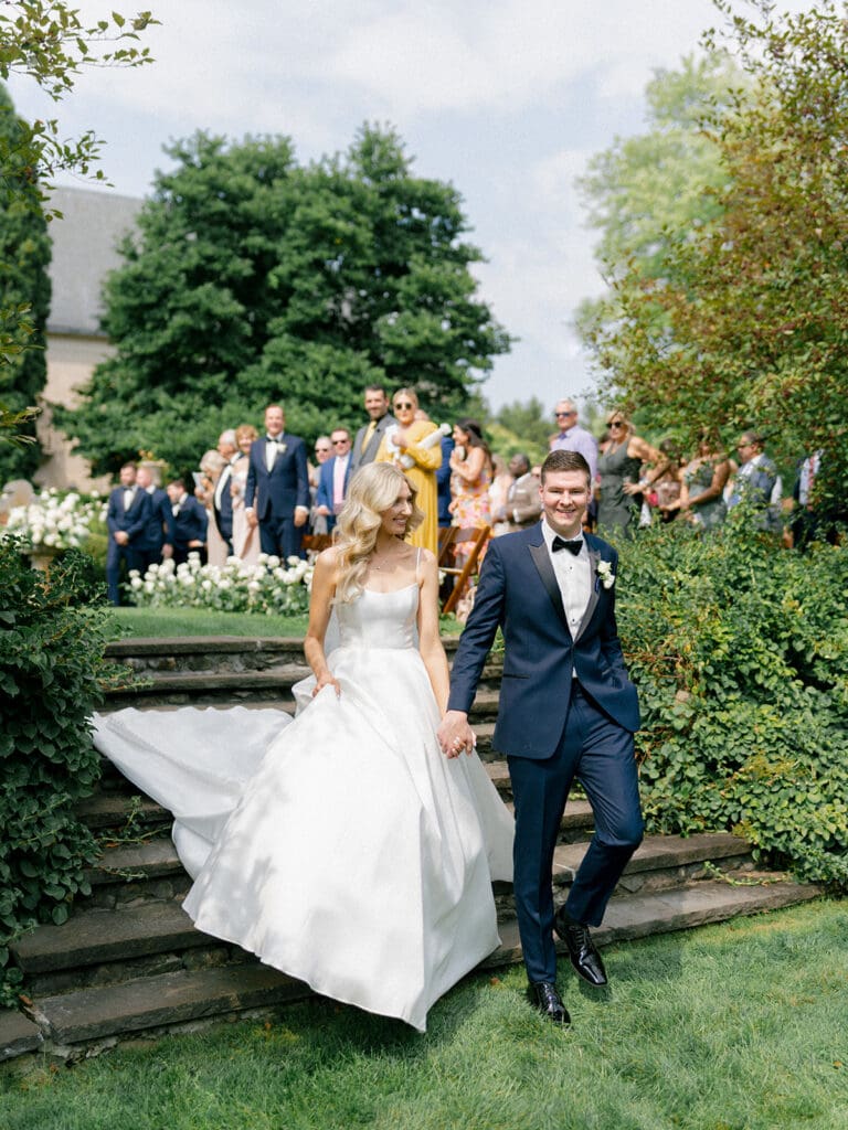 Bride and groom holding hands as they walked back down the aisle as husband and wife