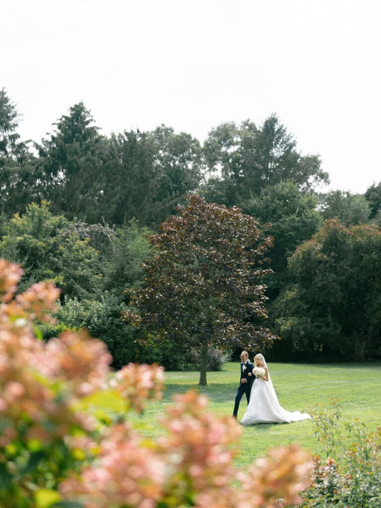 Bride being walked to her outdoor wedding ceremony by her father