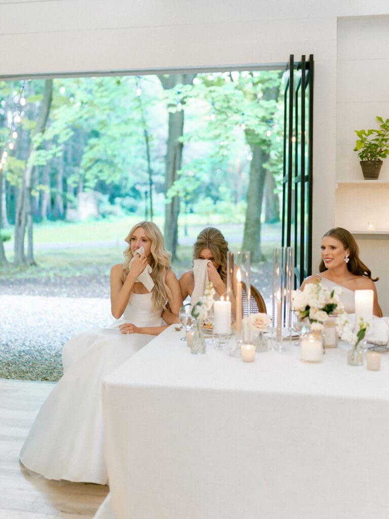 Bride and bridesmaids getting emotional as they watch the groom dance with his mother