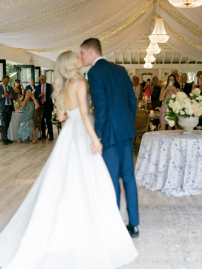 Bride and groom kissing during their wedding reception entrance