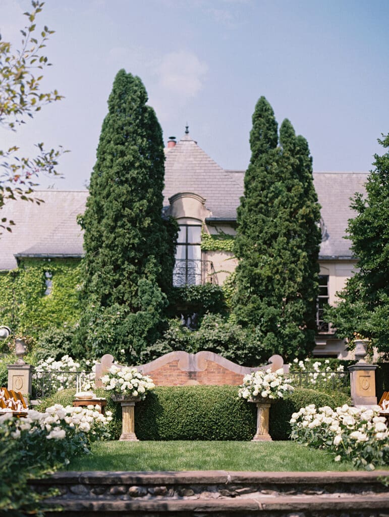 Outdoor summertime Greencrest Manor wedding ceremony with white roses lining the aisle