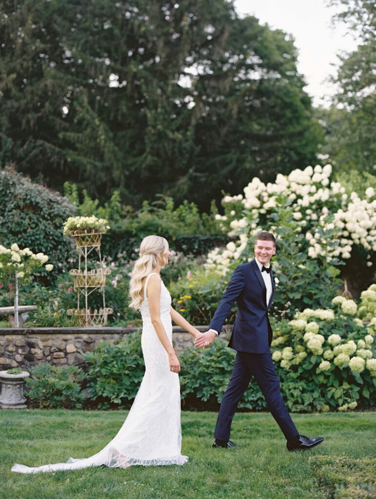 Bride and groom walking in the gardens at Greencrest Manor wedding venue in Battle Creek, Michigan