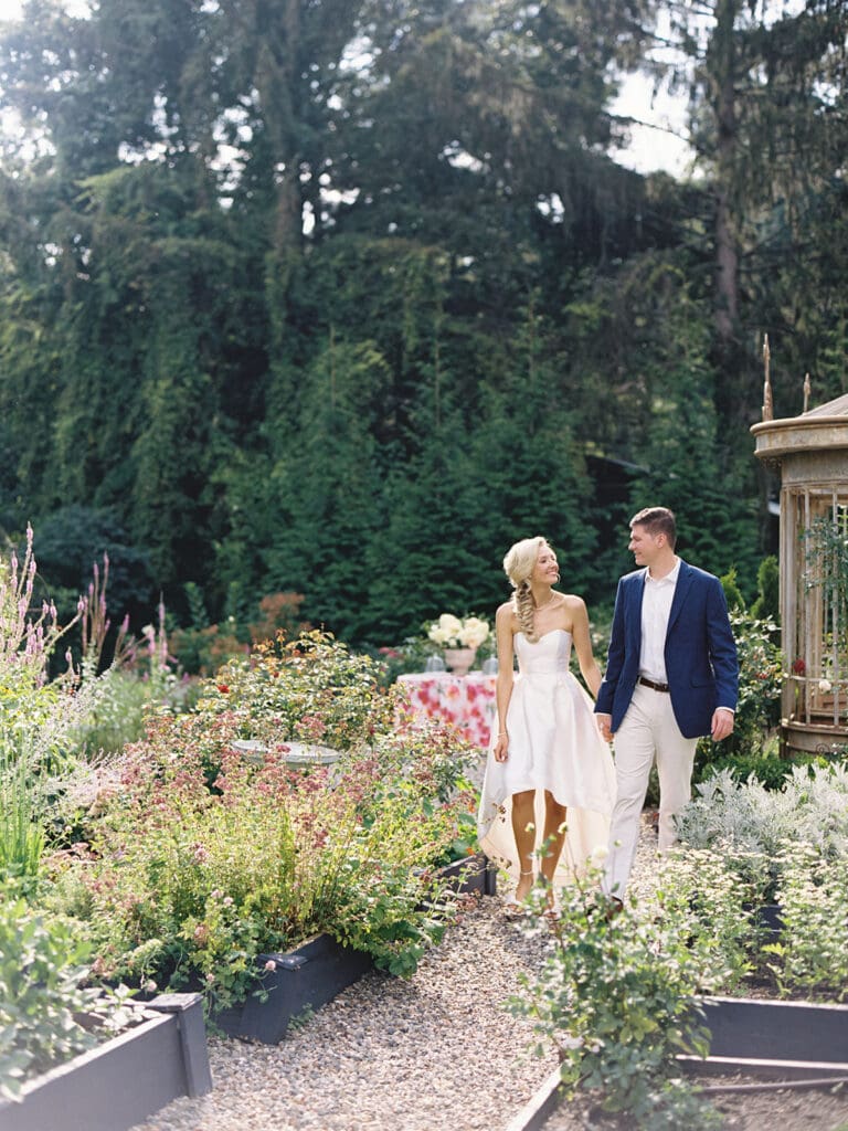 Bride and groom walking in the gardens of Greencrest Manor wedding venue in Battle Creek, Michigan for their welcome party