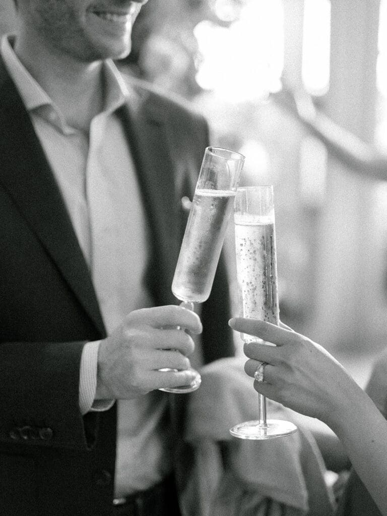 Black and white photo of a guests with glasses of champagne