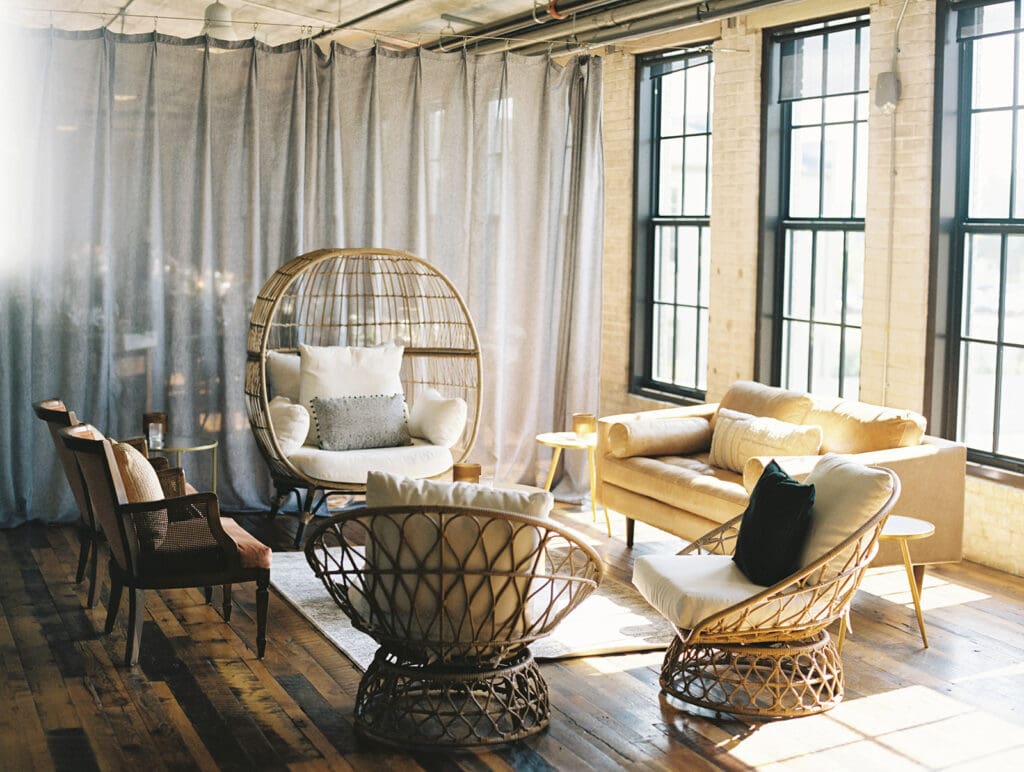 Cocktail hour space with wicker chairs at Journeyman Distillery wedding venue