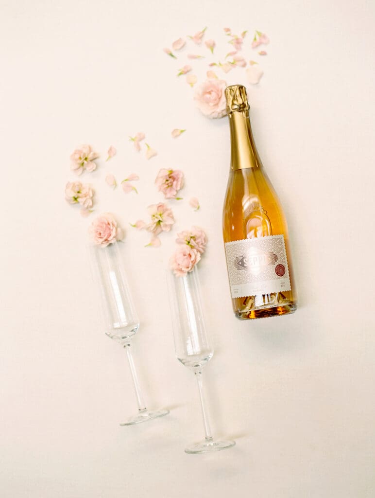 Seppi sparkling wine with two champagne glasses and florals