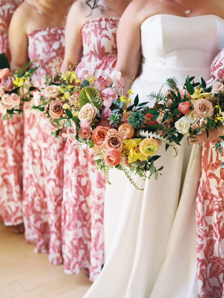 Bride and her bridesmaids holding lush tropical inspired wedding bouquets made by LB Floristry.