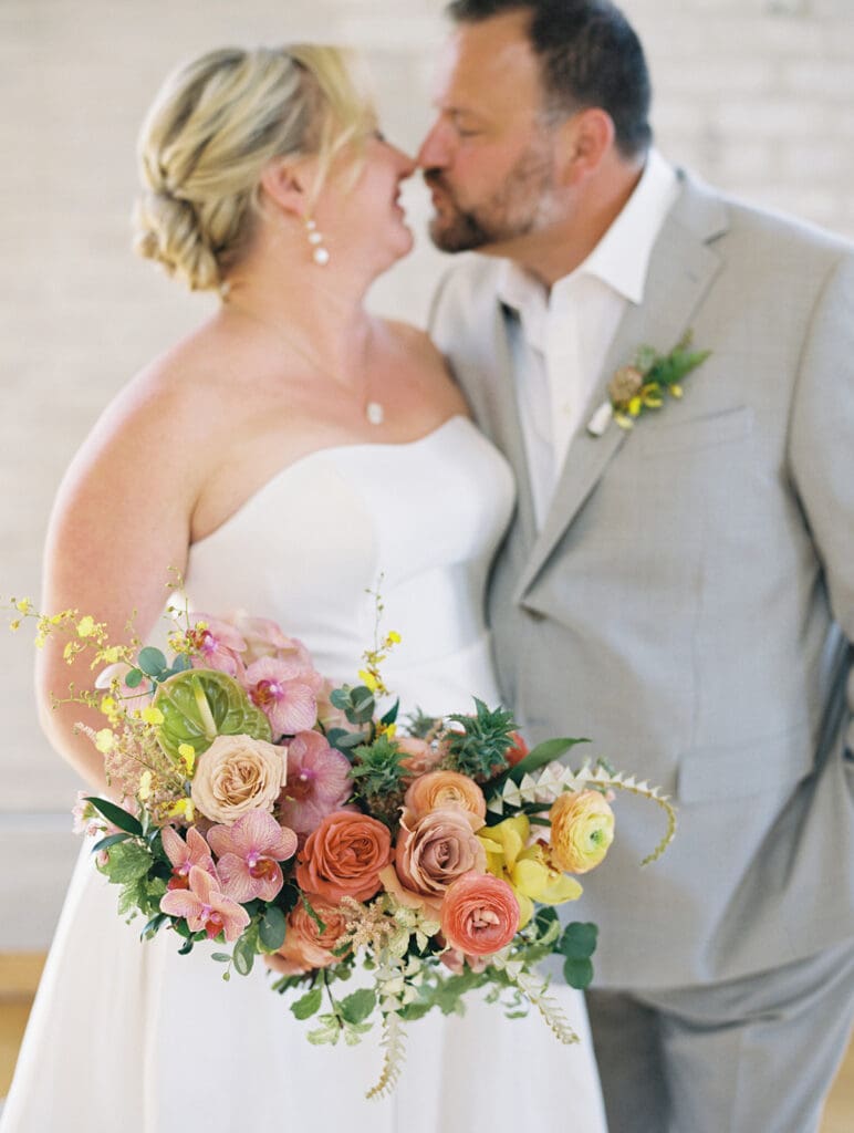 Bride and groom kissing during their wedding portraits at Journeyman Distillery wedding venue in Three Oaks, Michigan