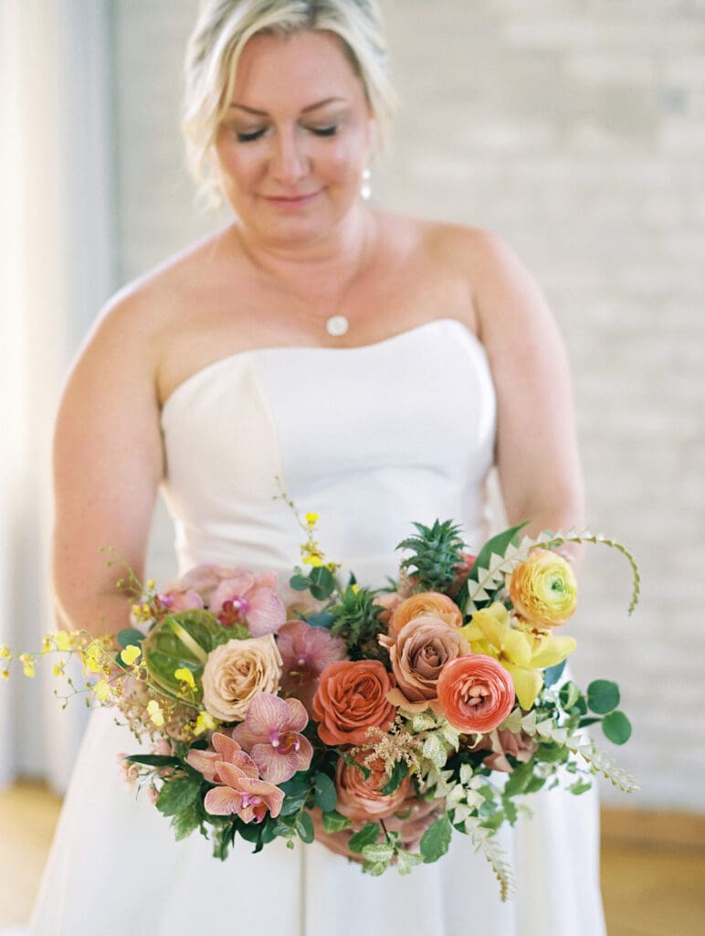 Bride holding a lush tropical inspired wedding bouquet made by LB Floristry