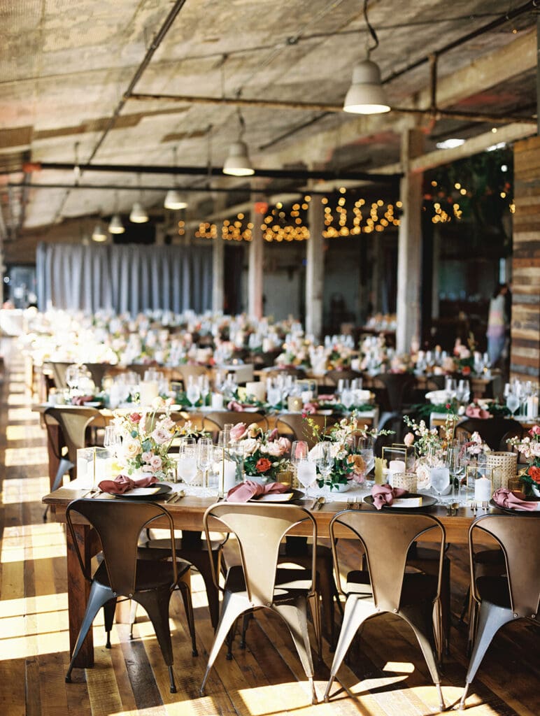 An indoor Journeyman Distillery wedding reception with a modern tropical fusion.