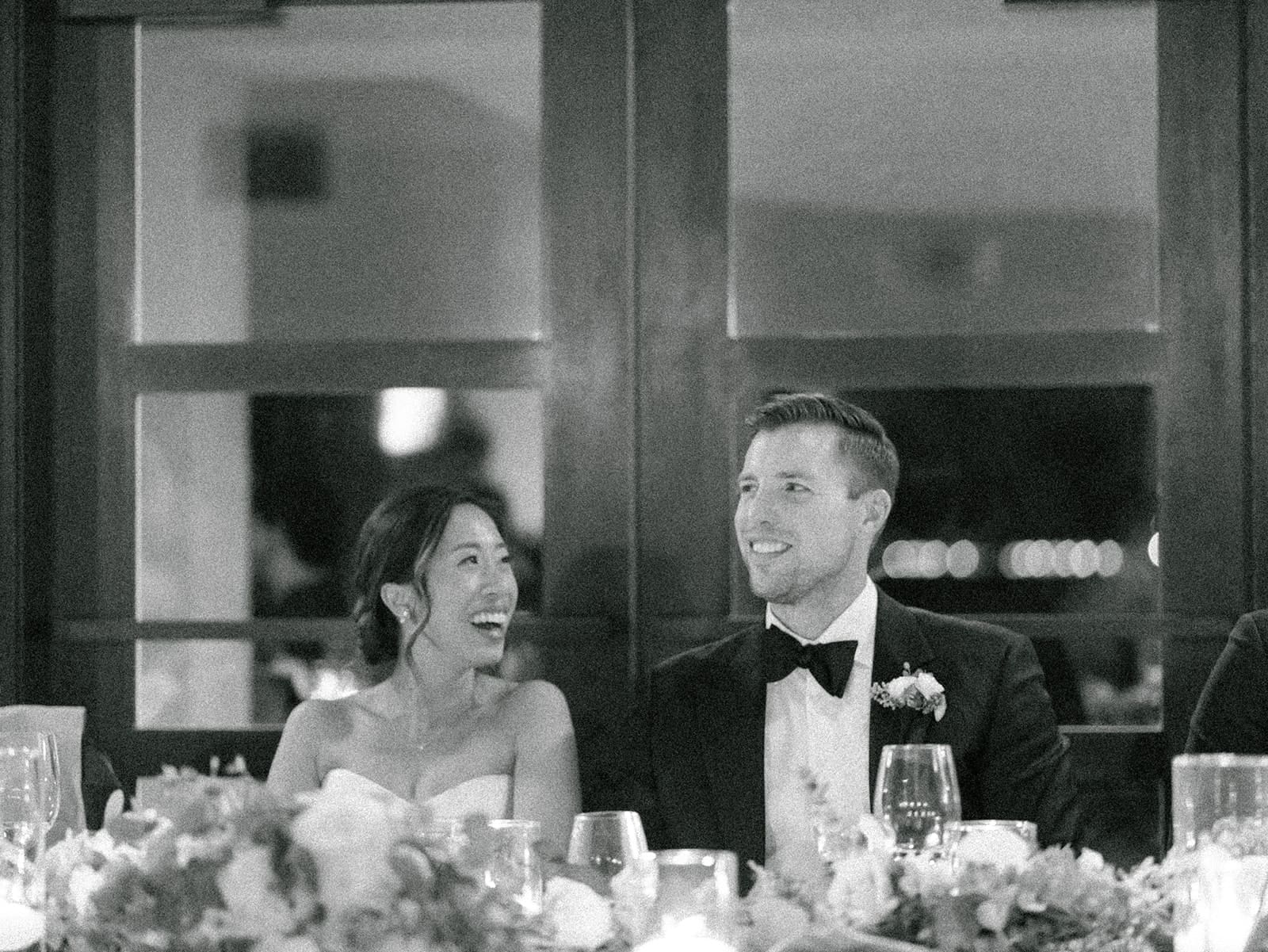 Black and white photo of a bride and groom during their wedding speeches