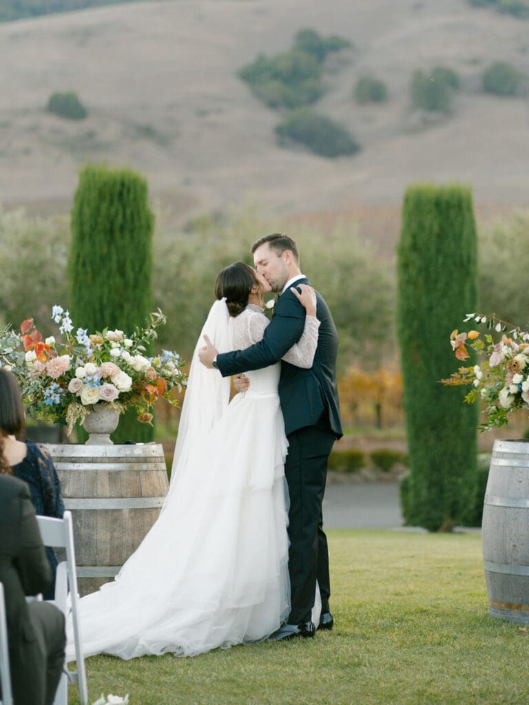 Bride and groom kissing during their Viansa Winery wedding ceremony