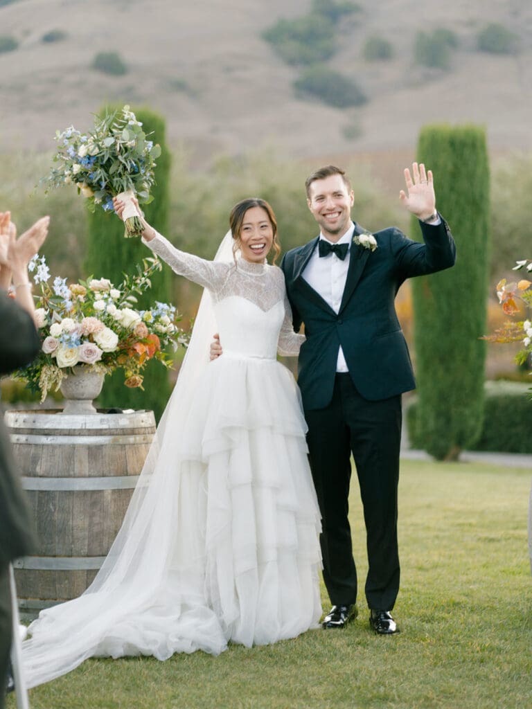 Bride and groom raising their arms in celebration of being husband and wife