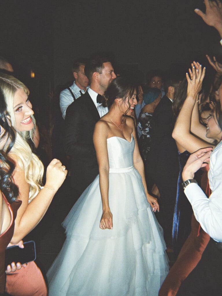 Film wedding reception photos of a bride and groom dancing