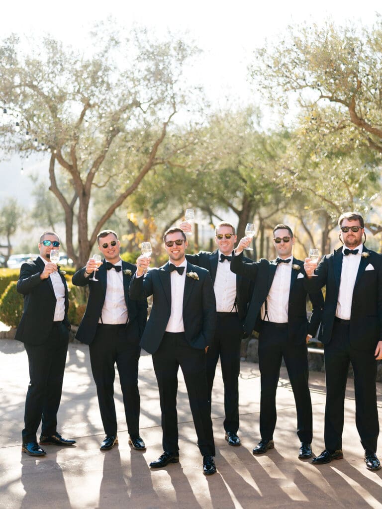 Groom and his groomsmen holding up their wine