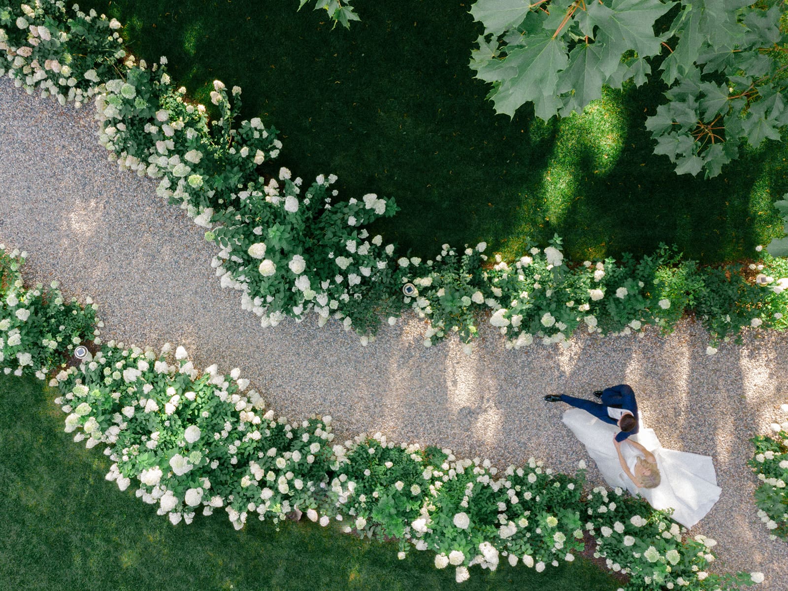 Bride and groom walking through the garden at Greencrest Manor - Estate wedding venue in Michigan