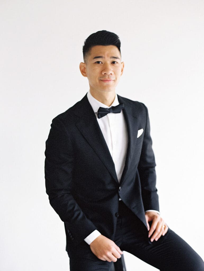 Grooms sitting on a stool for his in studio portraits in South Bend, Indiana