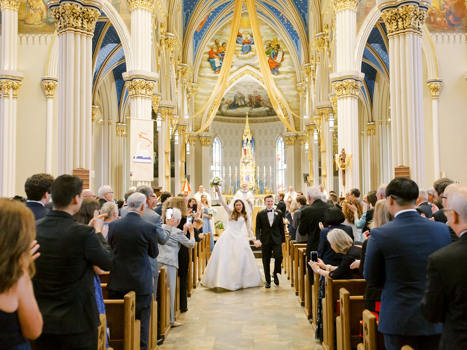 Bride and groom walking back down the aisle as husband and wife after their Cathedral Basilica of The Sacred Heart Wedding ceremony at Notre Dame