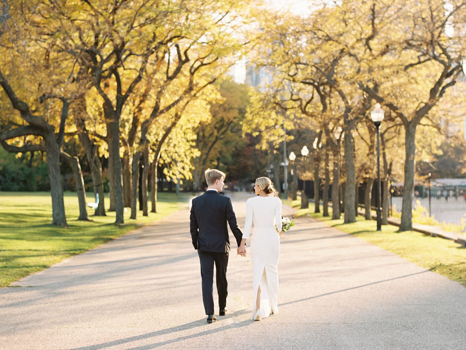 Bride and groom walking during the fall in Chicago for their wedding portraits