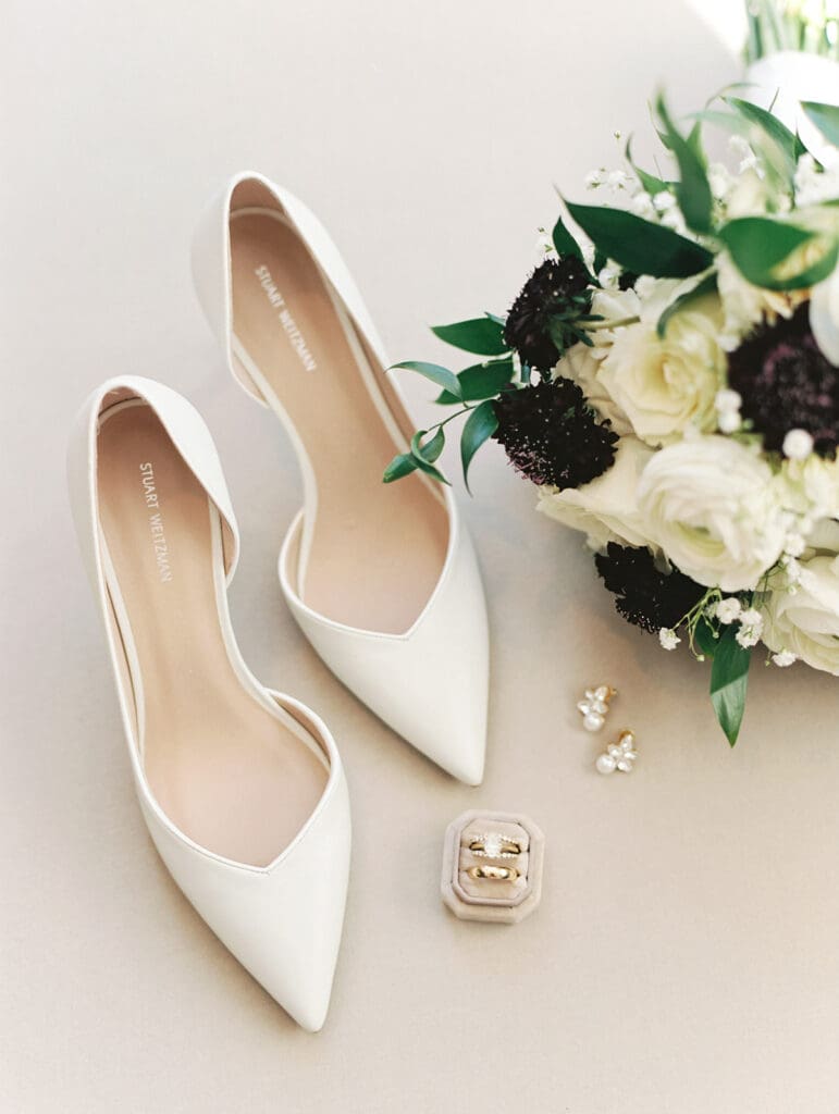 Classic bridal shoes, rings, and a wedding bouquet