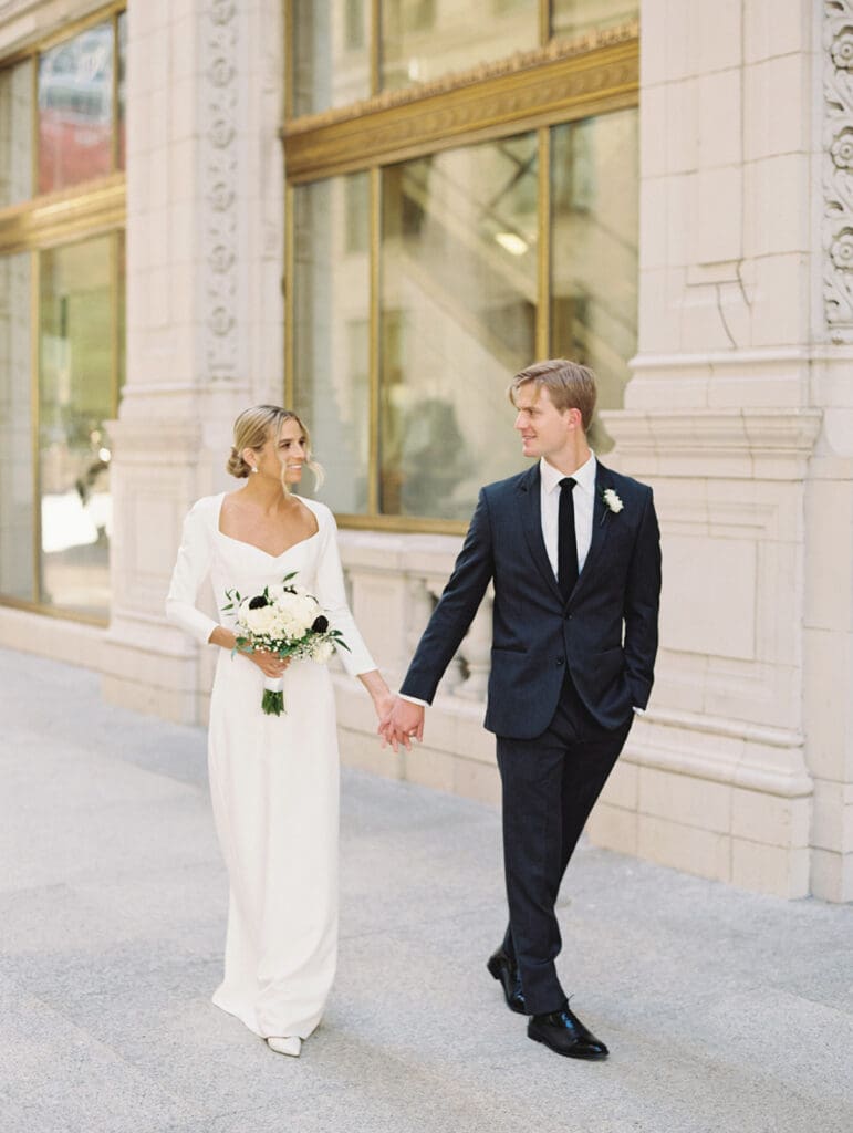 Bride and groom walking in downtown Chicago for their wedding portraits