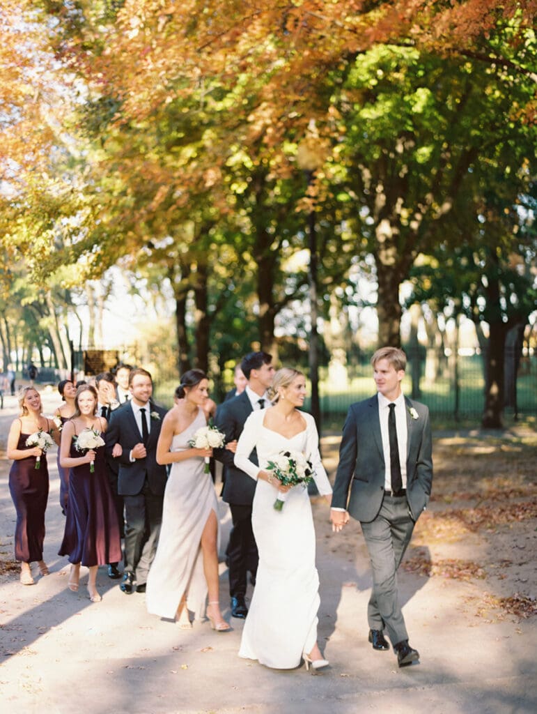 Bride, groom, and their entire wedding part walking for their downtown Chicago wedding portraits during the fall
