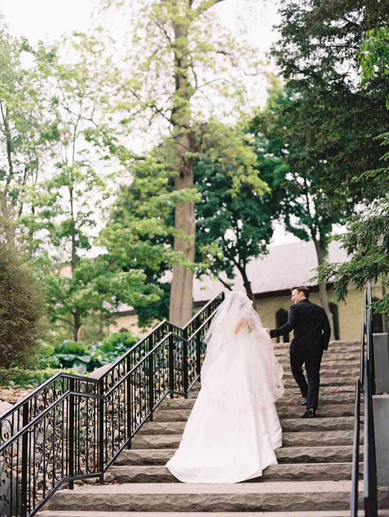 Bride and groom walking up a staircase during their University of Notre Dame wedding
