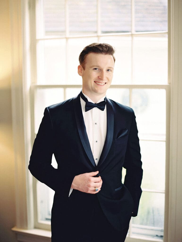 Indoor classic grooms portraits wearing a black suit and bowtie 