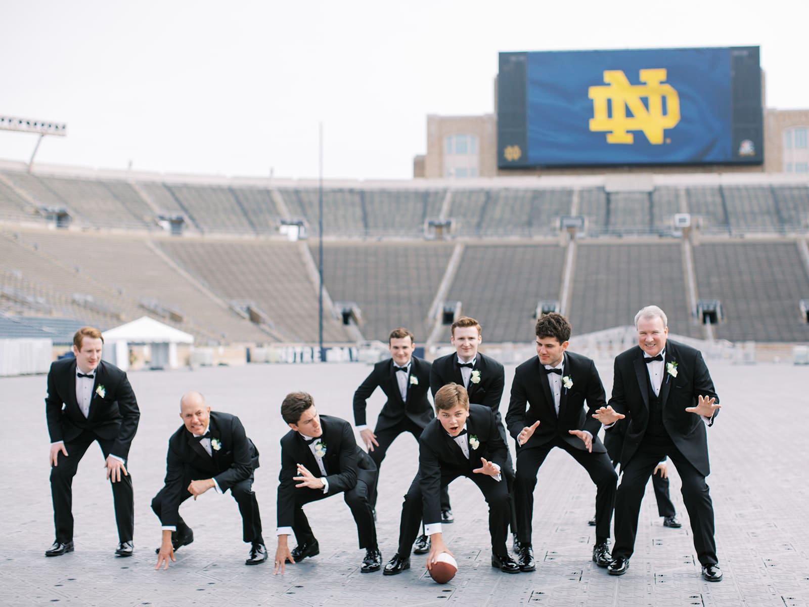 Fun groom and groomsmen football style photos from a University of Notre Dame wedding in Indiana
