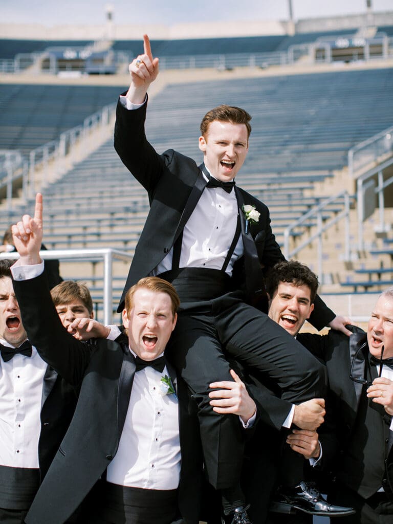 Fun groom and groomsmen football style photos from a University of Notre Dame wedding in Indiana