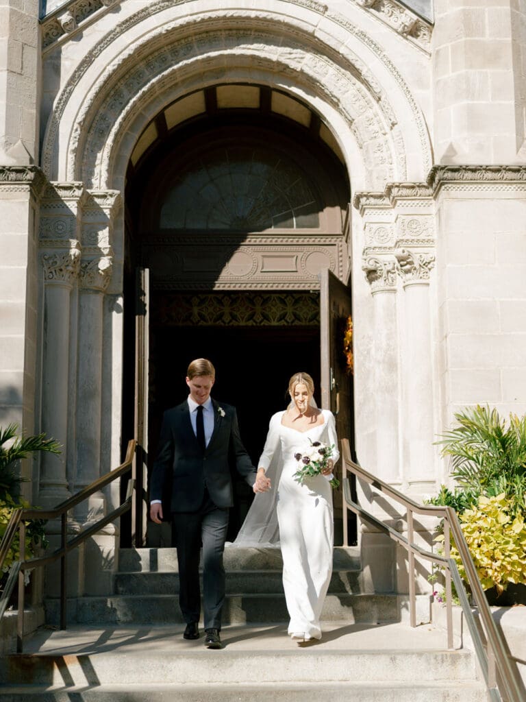 Bride and groom walking out of Saint Clement Parish after their downtown Chicago wedding ceremony